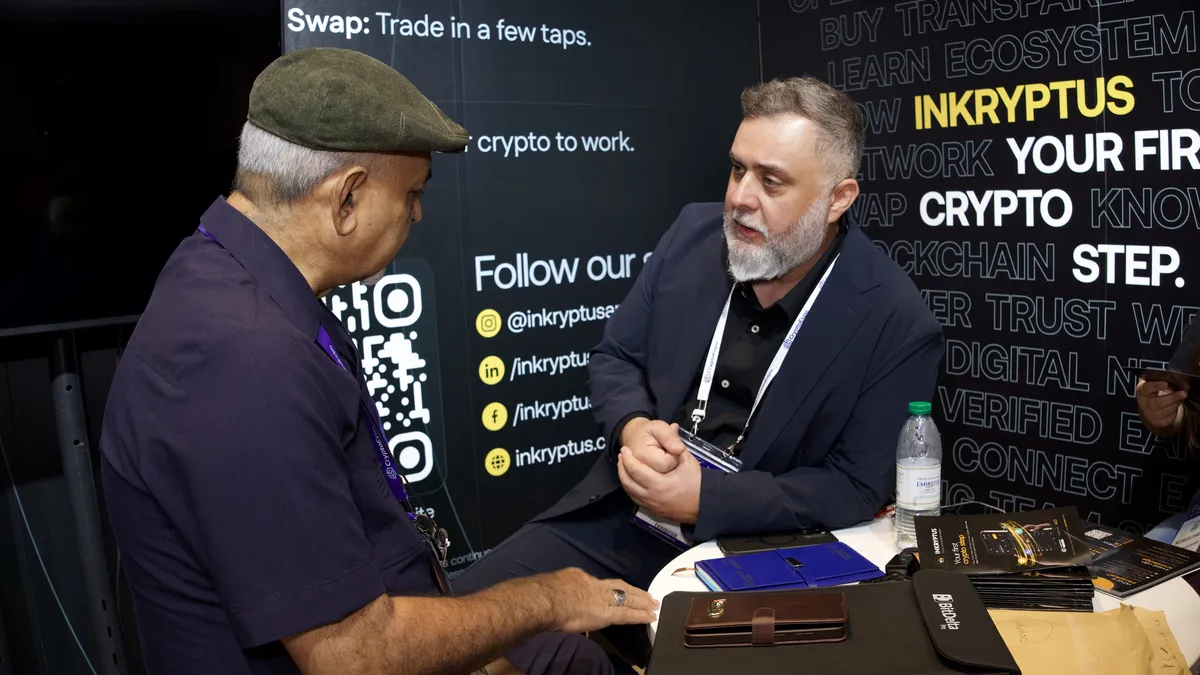 Un visitante en el stand de Inkryptus aprendiendo cómo funciona la app